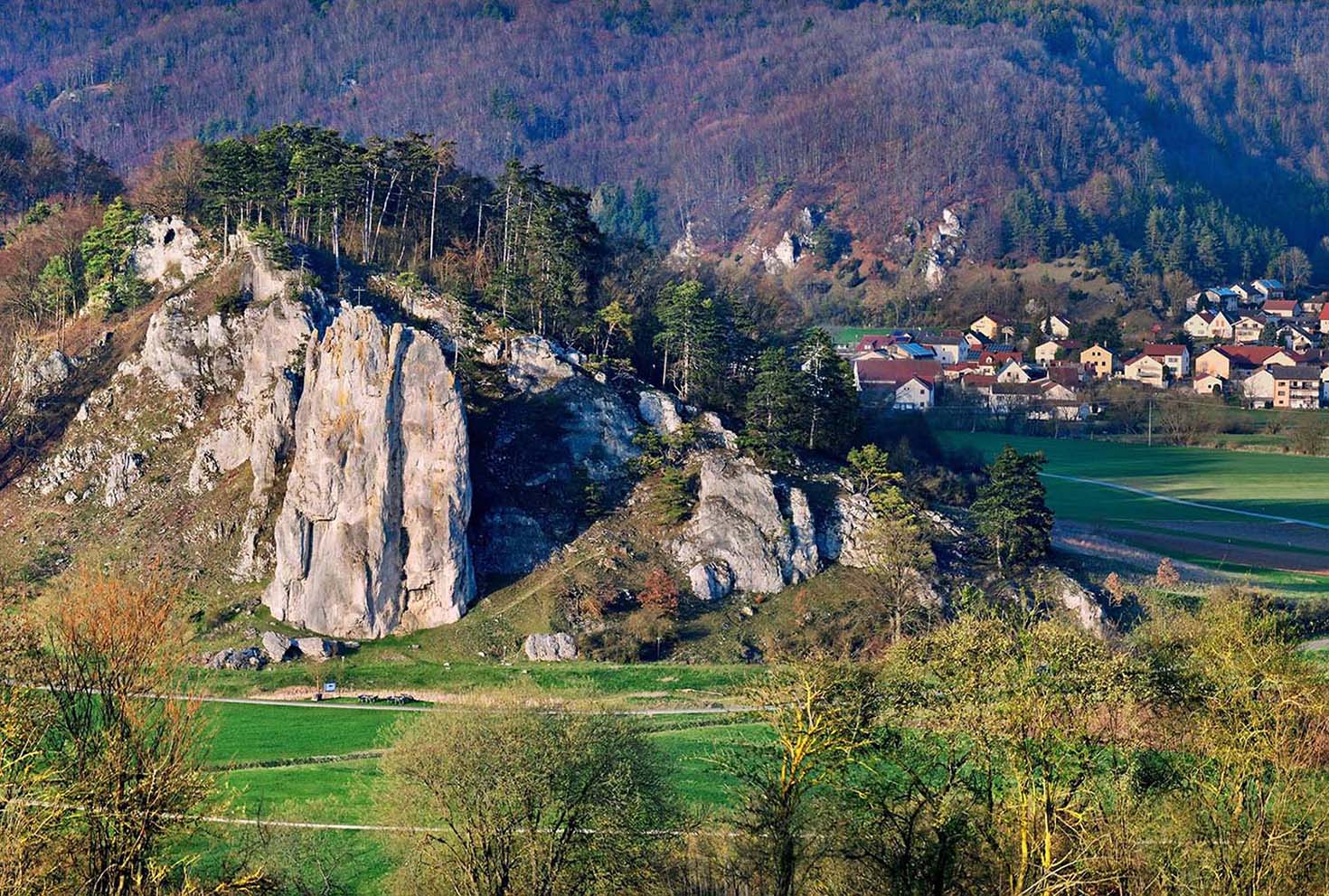 Rock group Burgsteinfelsen with the village of Breitenfurt in the Altmühltal nature park Park, Bavaria, Germany © Shutterstock