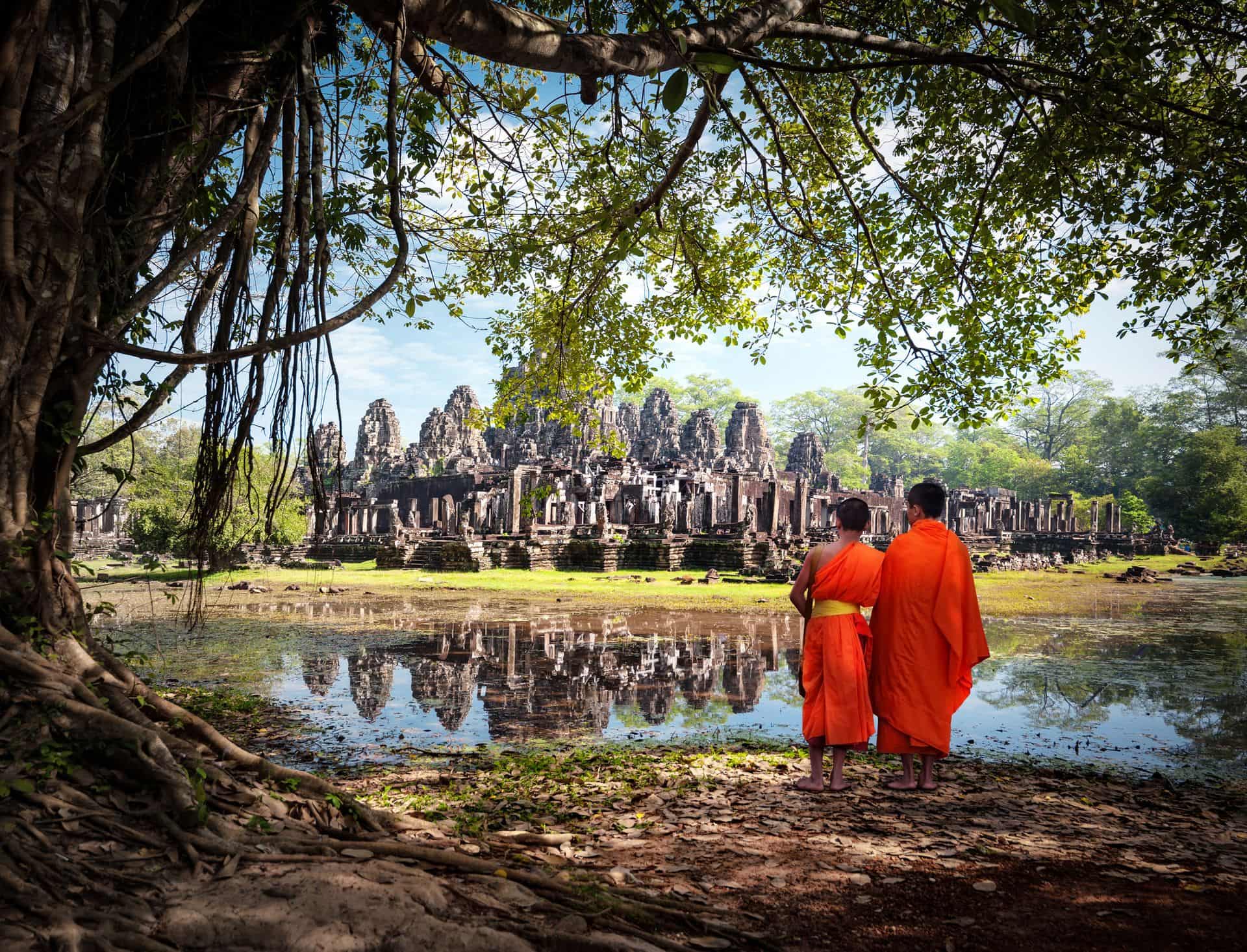 Angkor Wat monk. Ta Prohm Khmer ancient Buddhist temple in jungle forest. Famous landmark, place of worship and popular tourist travel destination in Asia