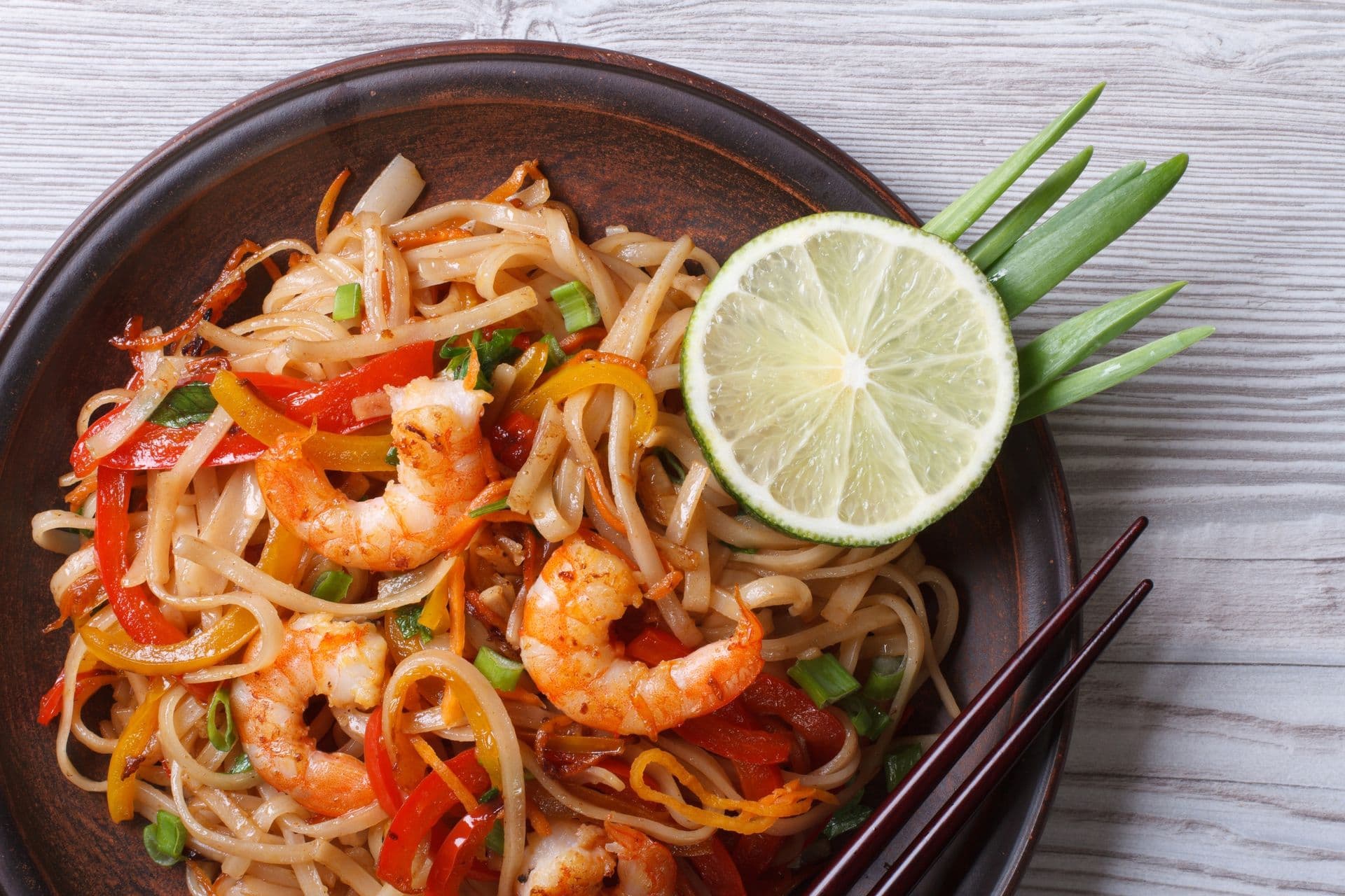 Asian rice noodles with shrimp and vegetables close-up on the table. top view of a horizontal