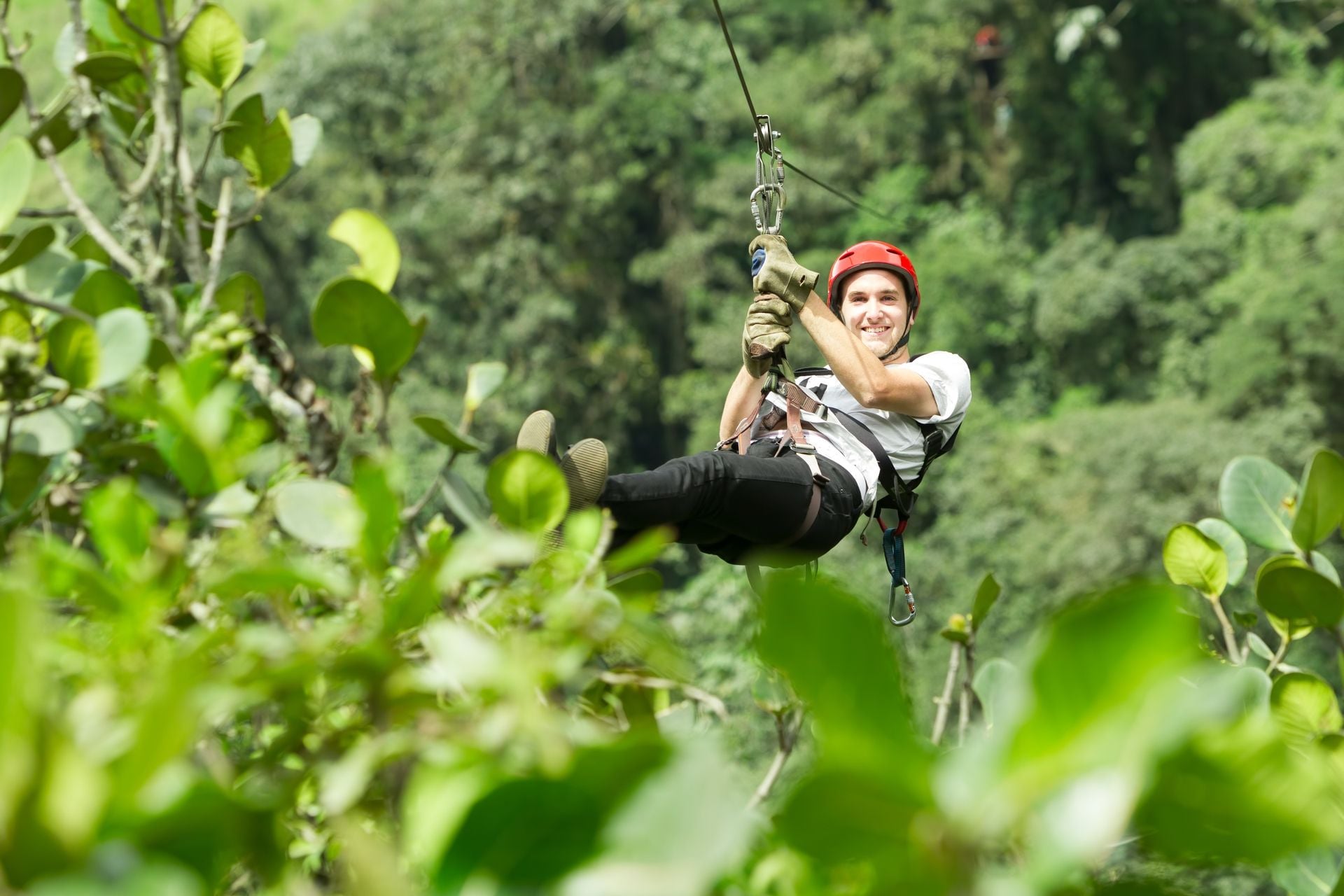 ADULT MAN ON ZIP LINE, ANDES RAIN FOREST IN ECUADOR