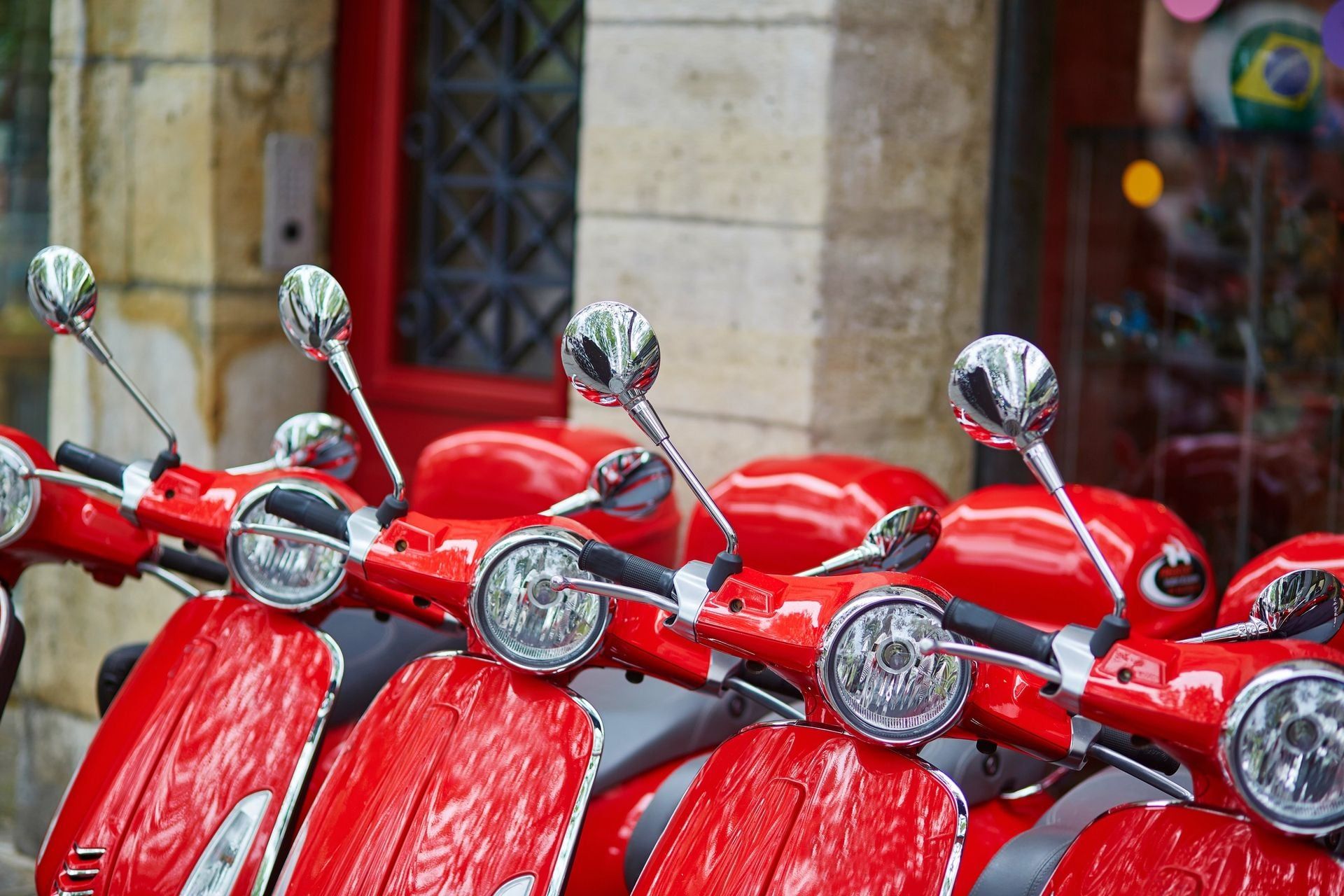 Row of red retro scooters parked on a Parisian street