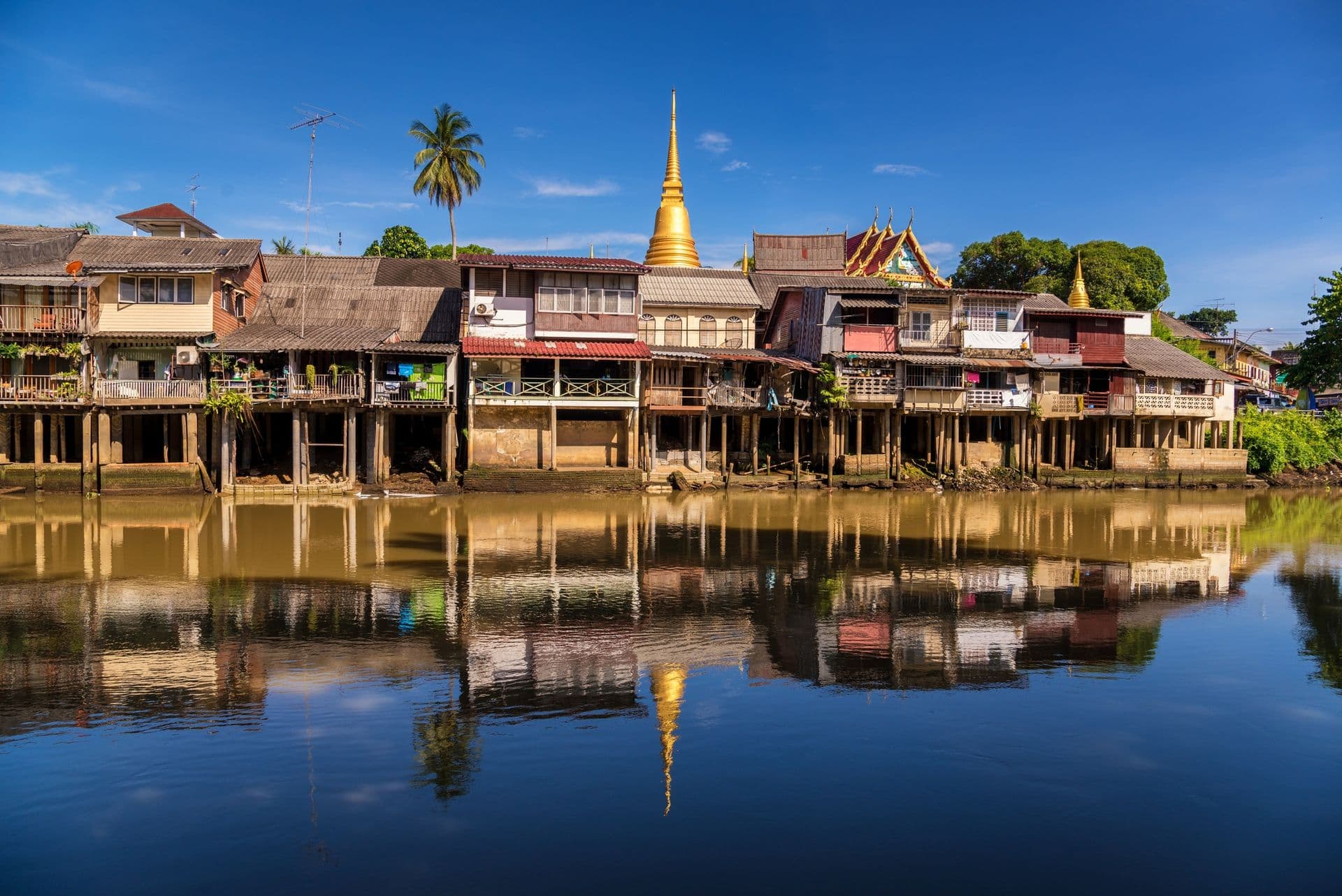 village near river in morning with clear blue sky at chantaboon village in chantaburi , Thailand
