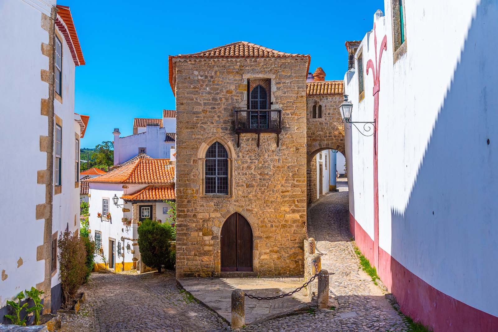 a narrow street inside of the obidos castle in Portugal © Shutterstock