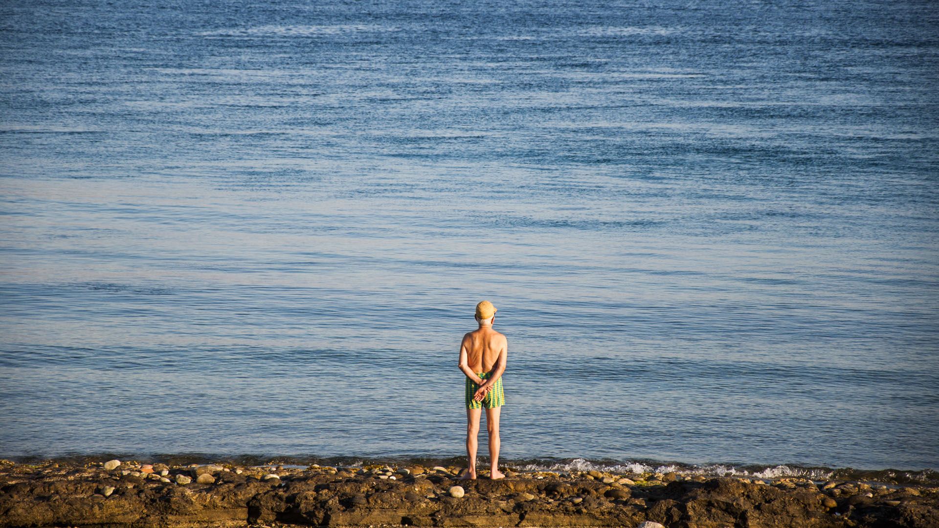 Old man watching the sea in the evening, Messina, Sicily, Italy © Marco Crupi/Shutterstock