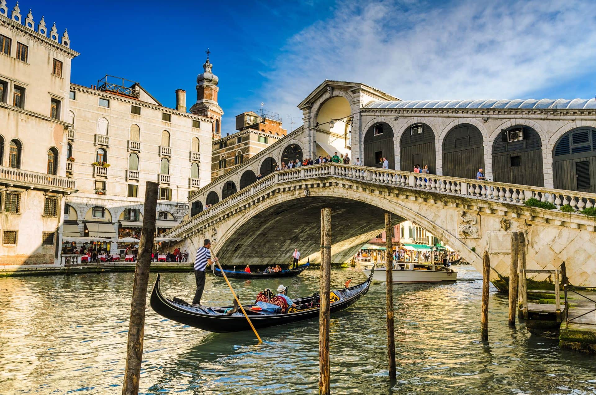 Gondola at the Rialto bridge with evening light in Venice, Italy