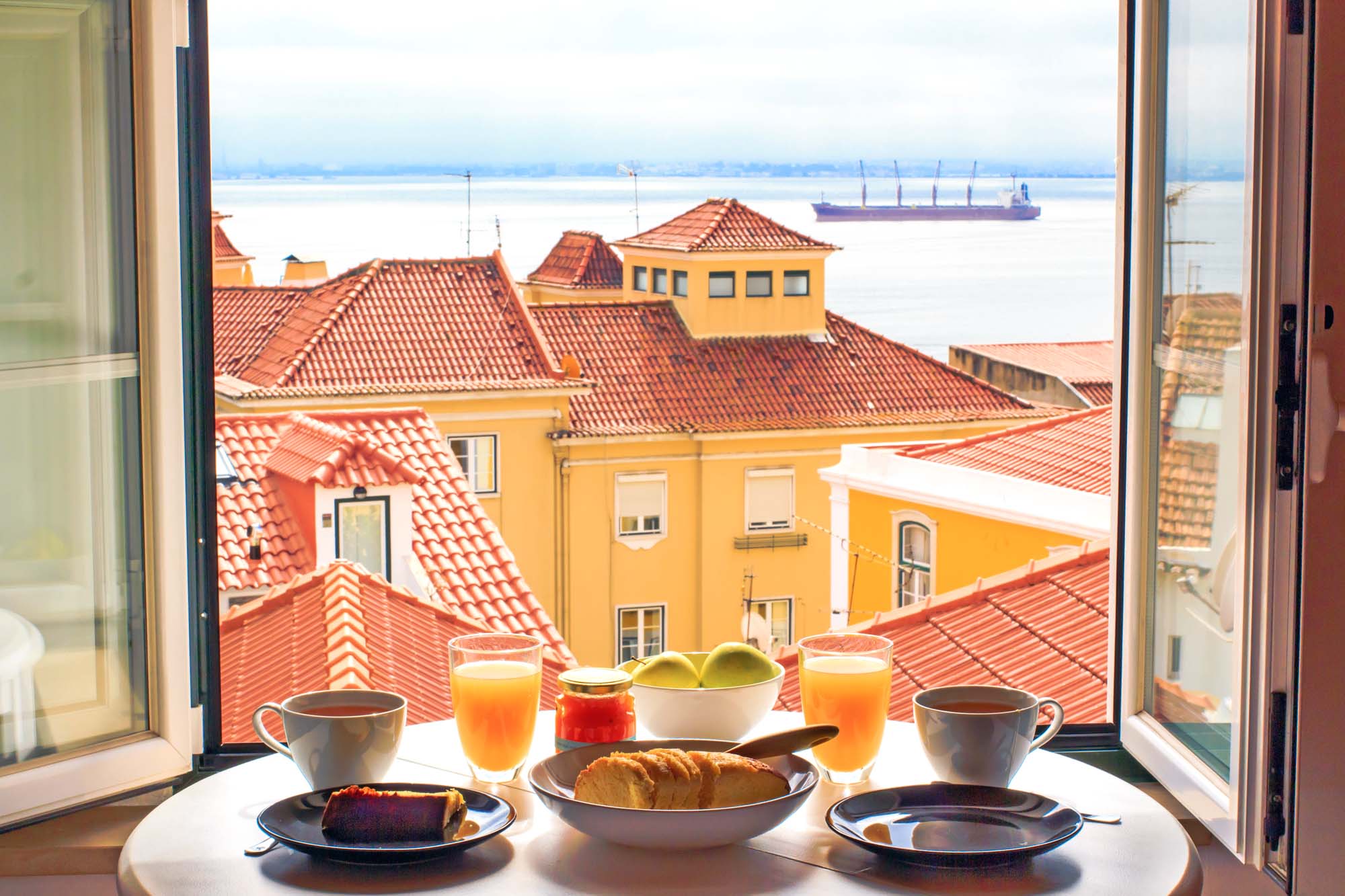 Romantic breakfast by window with a view in Lisbon, Portugal