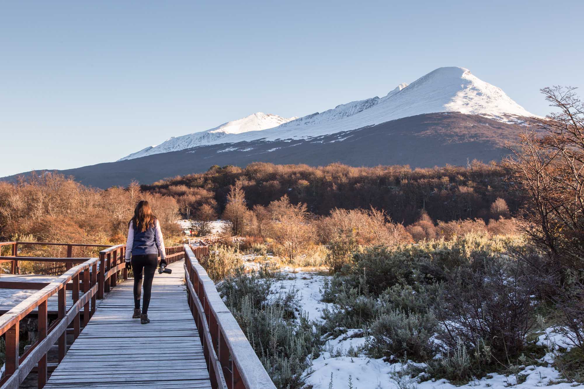 Woman walking in a balcony with a beautiful landscape in the background.