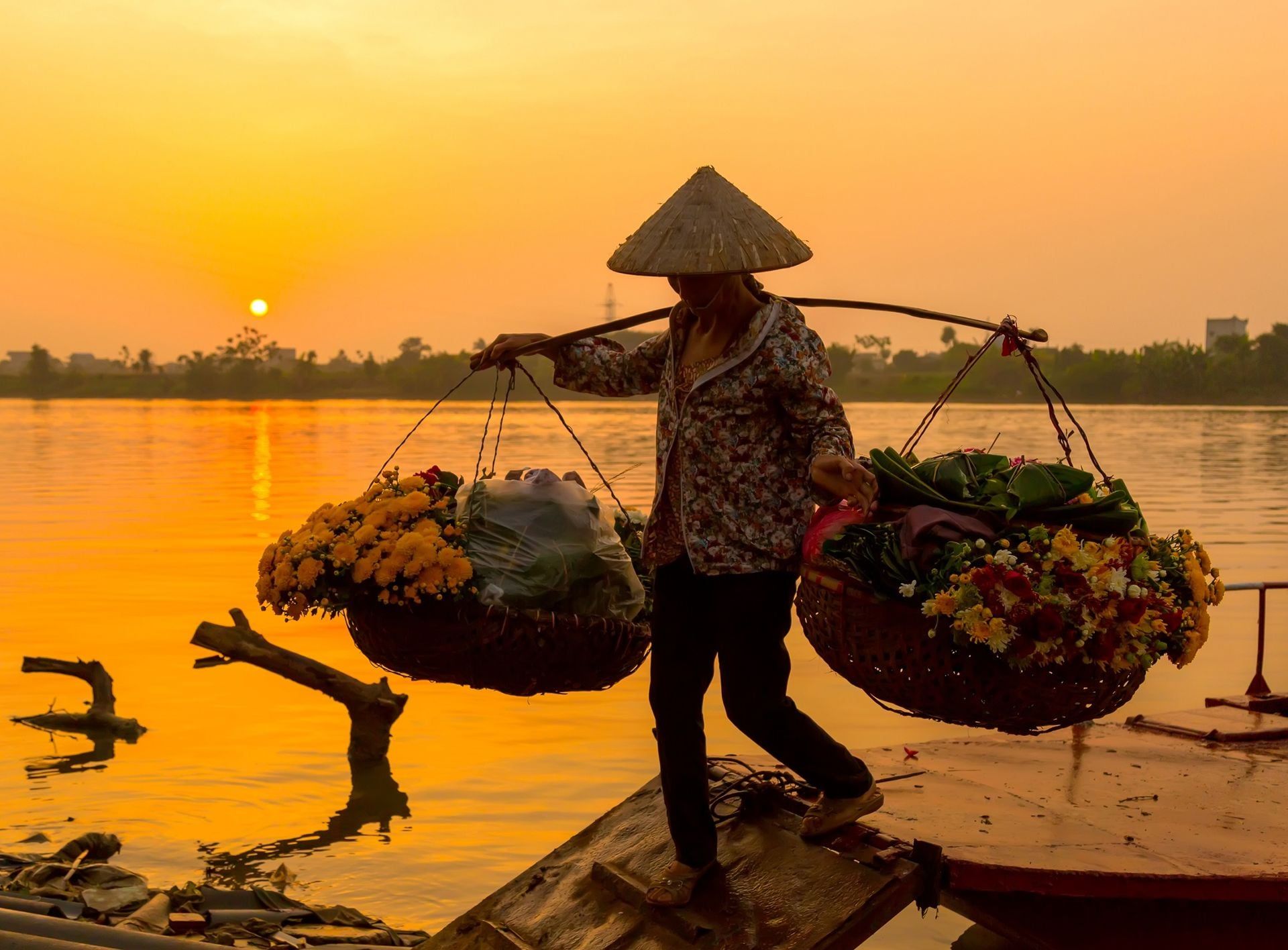 Women selling flowers on a boat in the early morning