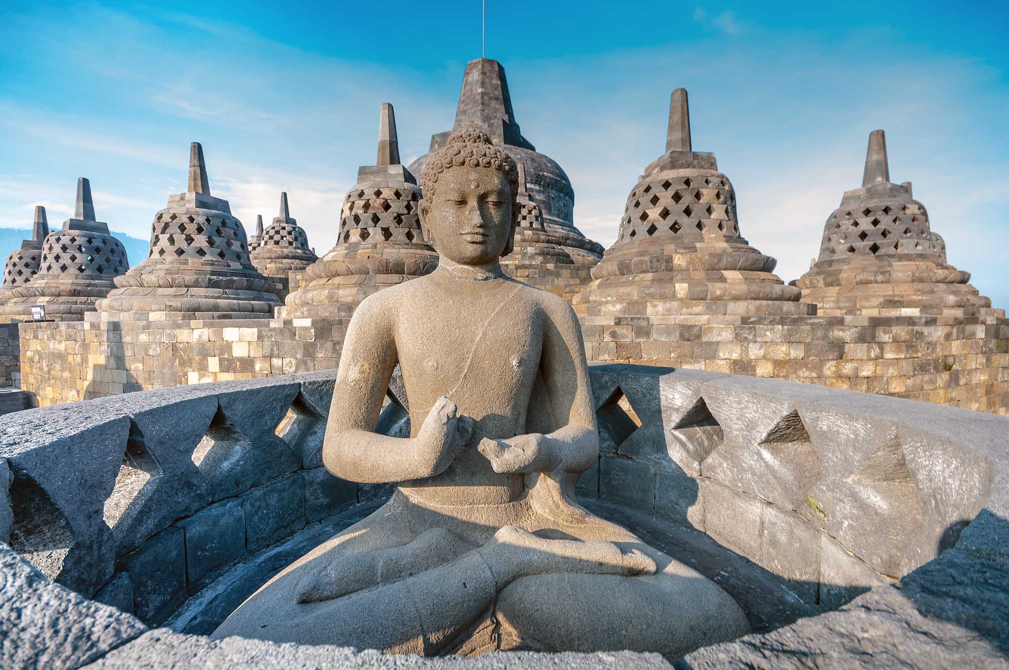 Ancient Buddha statue and stupa at Borobudur temple in Yogyakarta, Java, Indonesia.