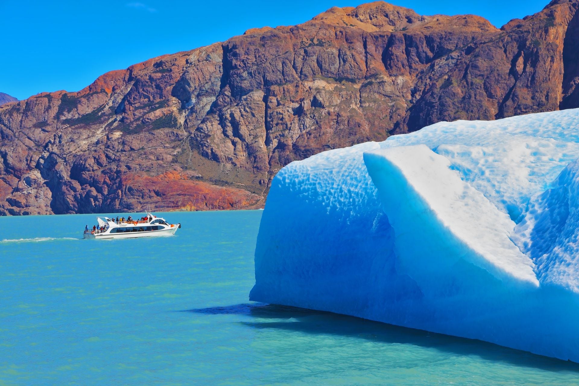 Ice and sun Patagonia, Argentina. Excursion on the tourist boat on Lake Viedma. White and blue huge icebergs floating near the ship broadside