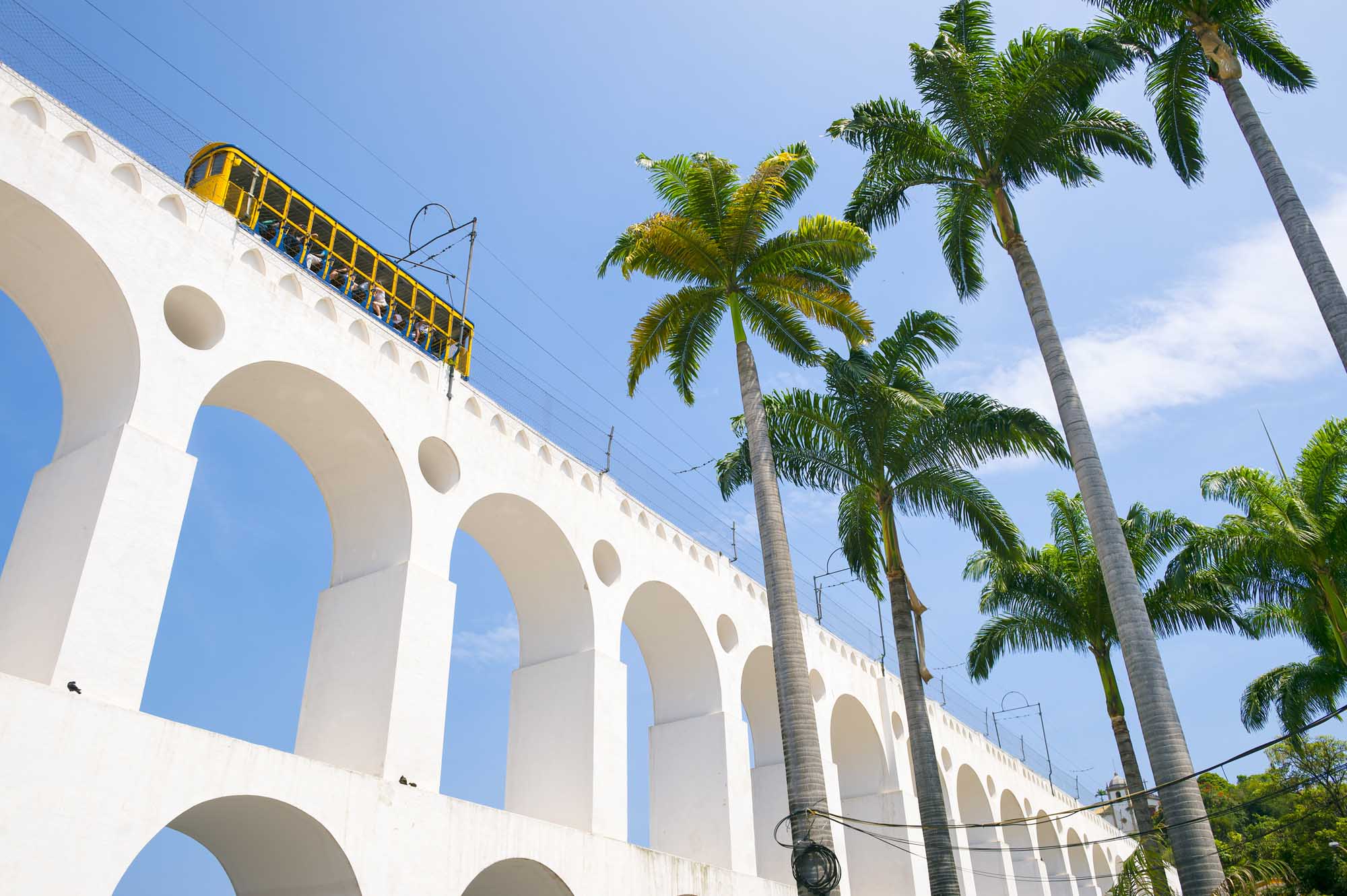 Train drives along distinctive white arches of the landmark Lapa Arches in Rio de Janeiro, Brazil