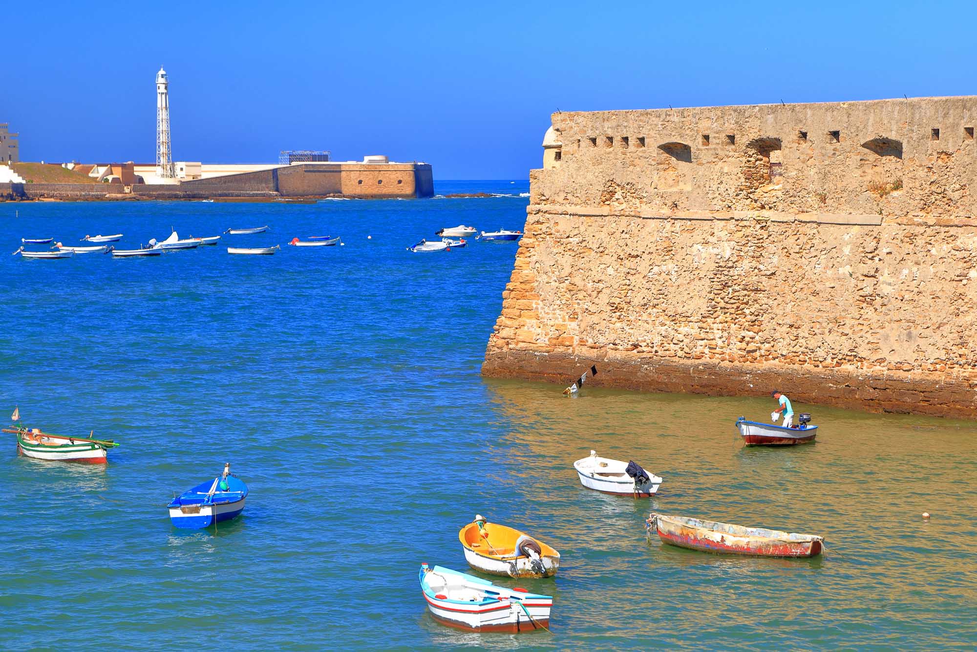 Small wooden boats near the walls of Santa Catalina Castle in Cadiz, Andalusia