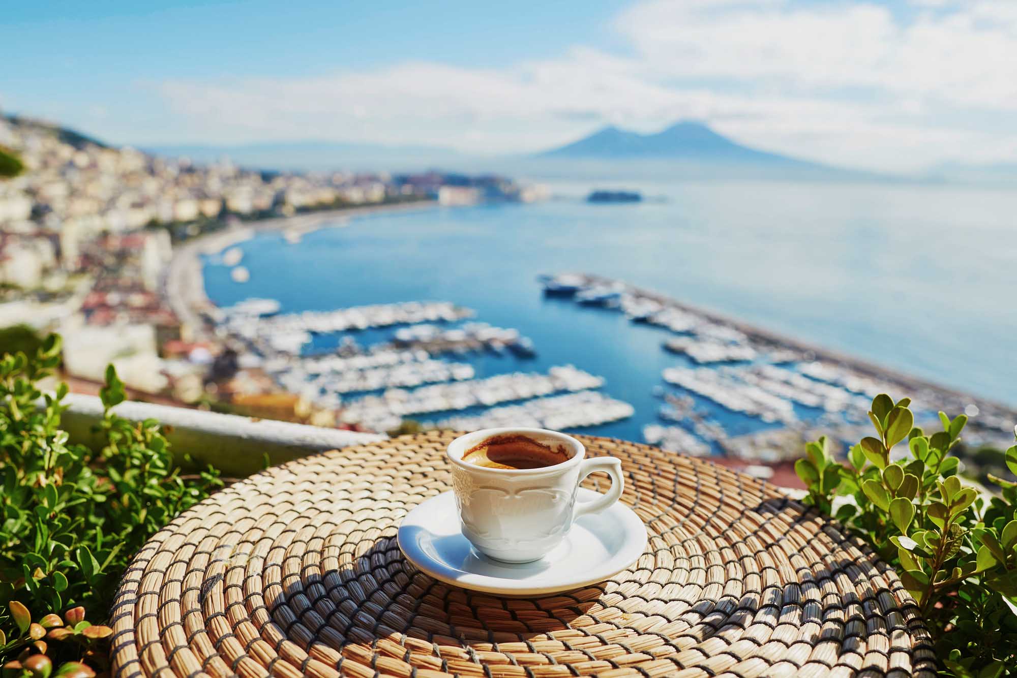 Cup of fresh espresso coffee in a cafe with view on Vesuvius mount in Naples