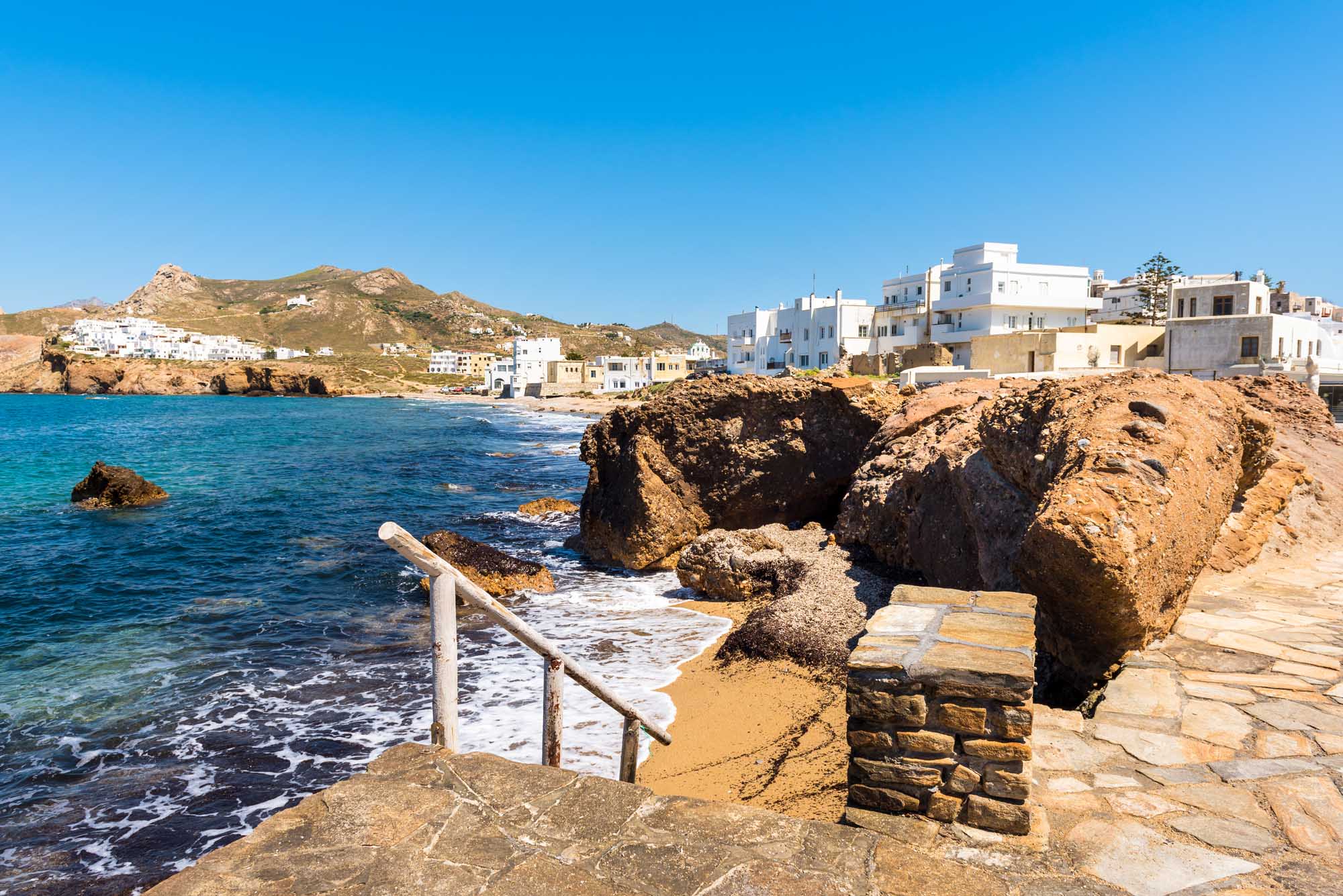 View of Naxos (Chora) town and blue sea water from coastal promenade. Naxos island, Greece.