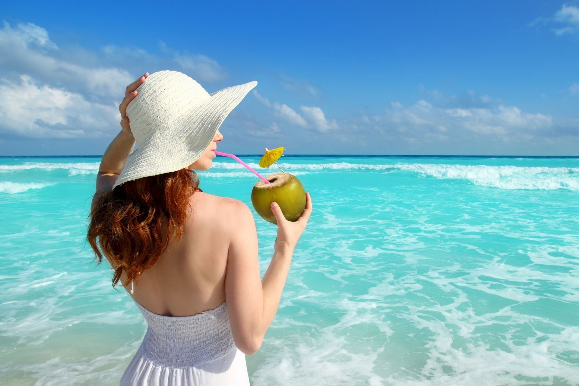 beach hat profile girl drinking a coconut fresh cocktail in tropical Caribbean sea